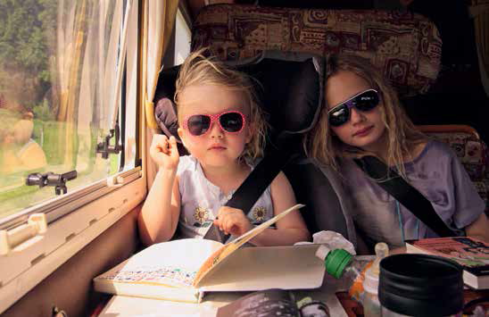 Zwei Kinder im Campingbus beim Lesen