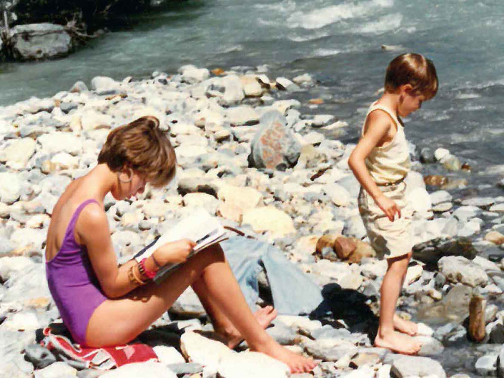 zwei Kinder sitzen an einem Fluss
