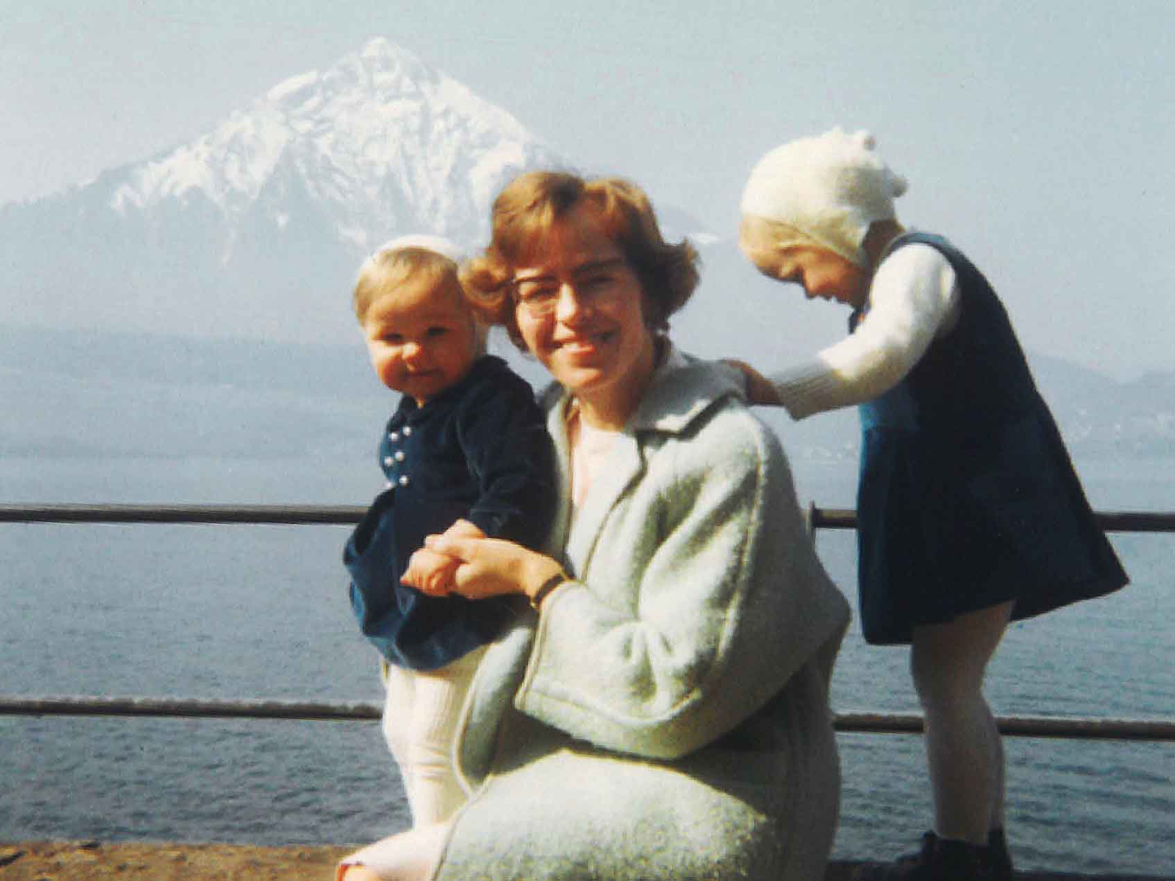 Mutter sitzt mit ihren beiden Kindern in Sonntagskleidung am Thunersee