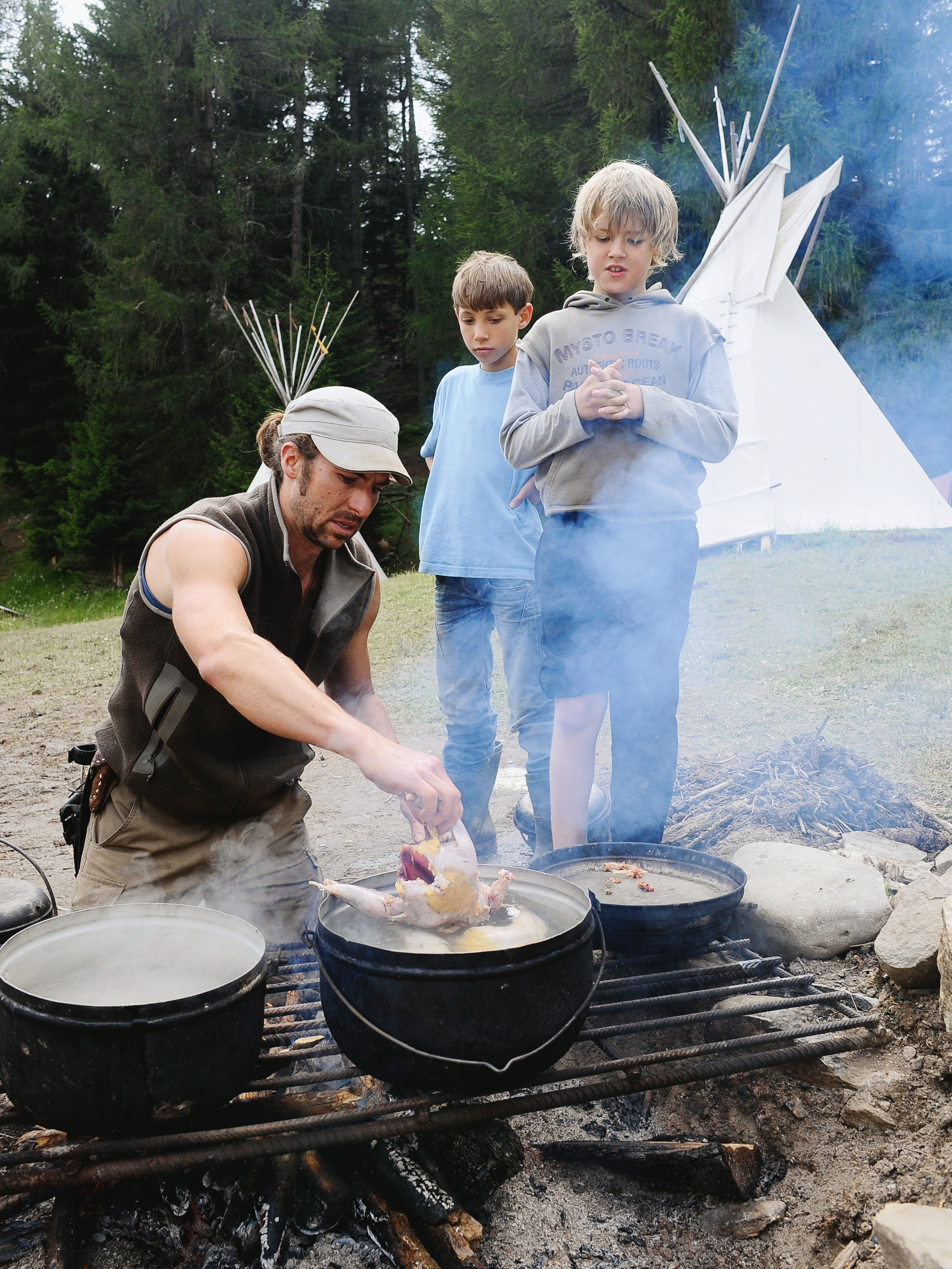 Kinder kochen auf dem Feuer
