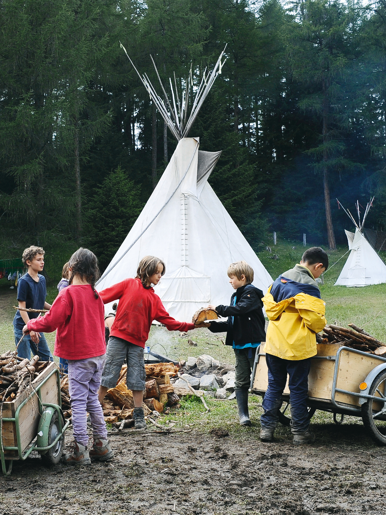 Kinder spalten Holz fürs Lagerfeuer