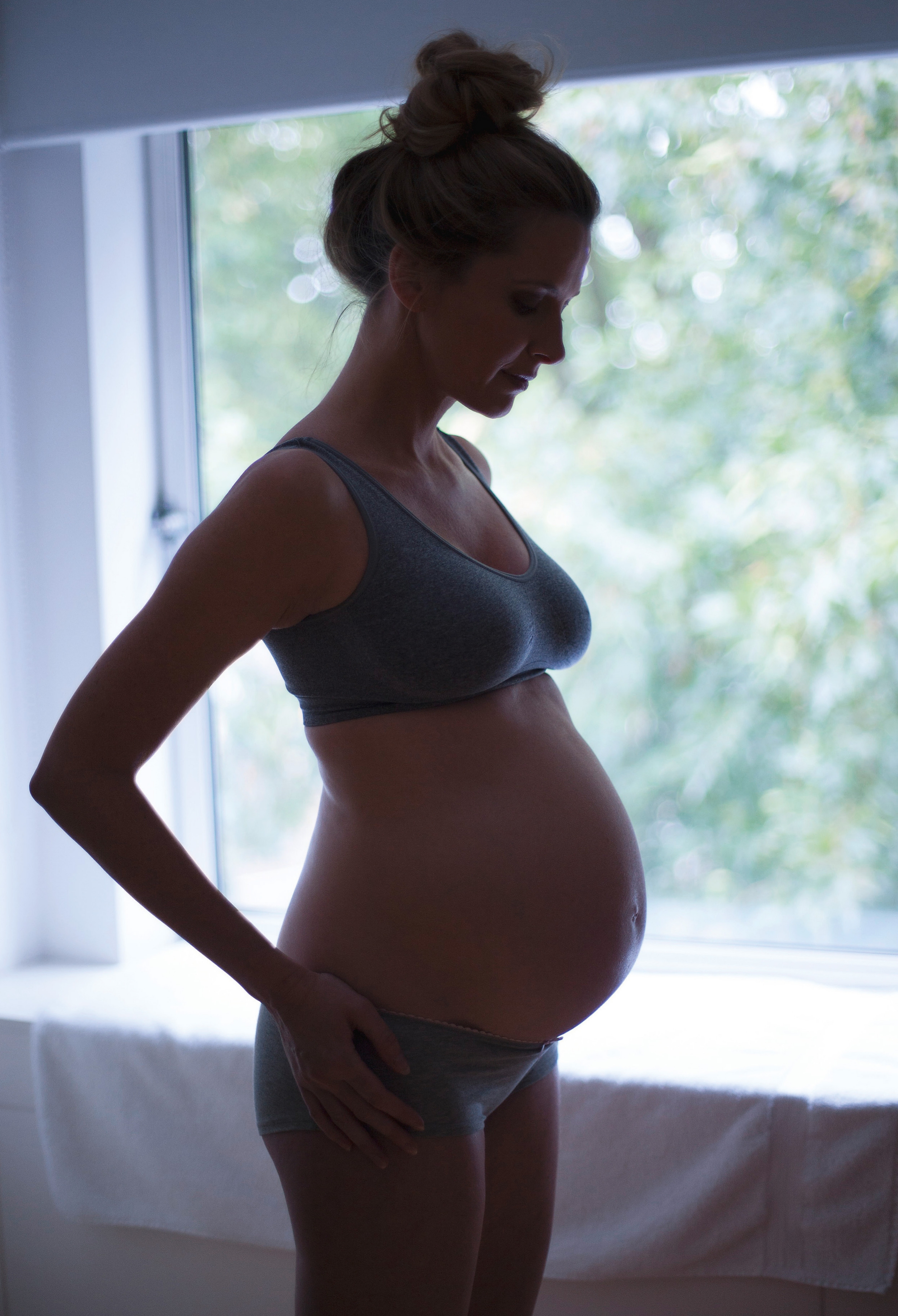 Schwangere Frau in Unterwäsche im Profil