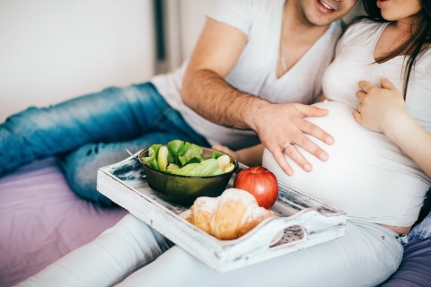 Schwangere Frau mit Mann beim Essen