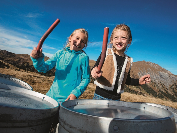 Kinder machen Musik auf Milchkannen