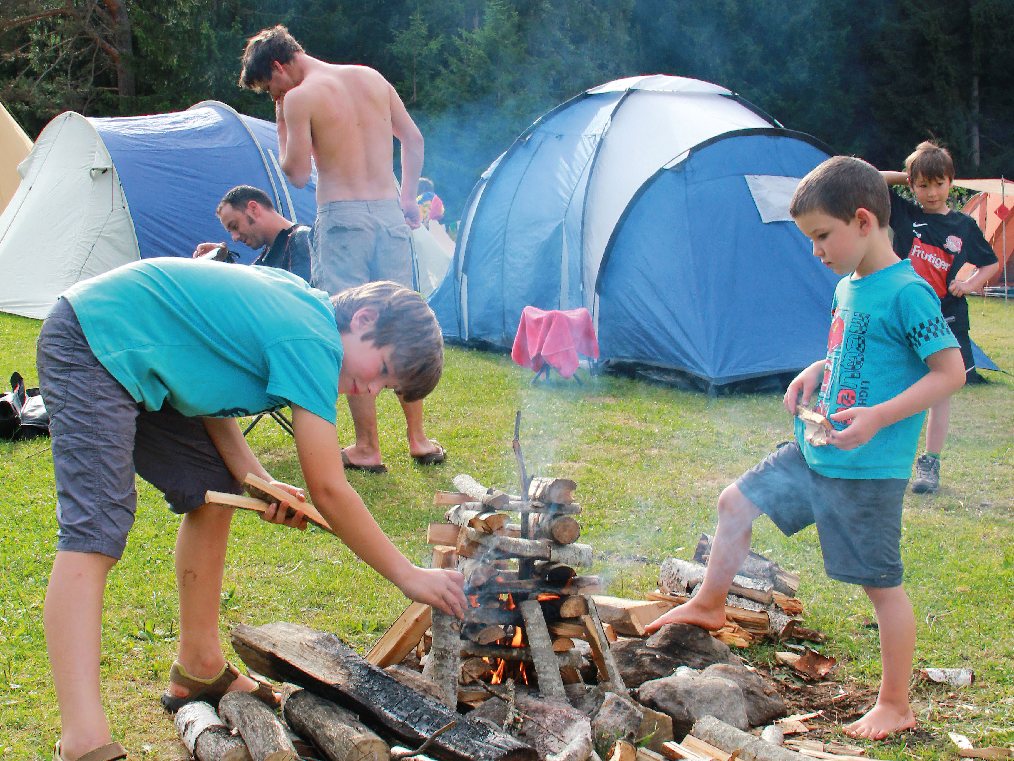 Zwei Kinder stehen um ein Feuer