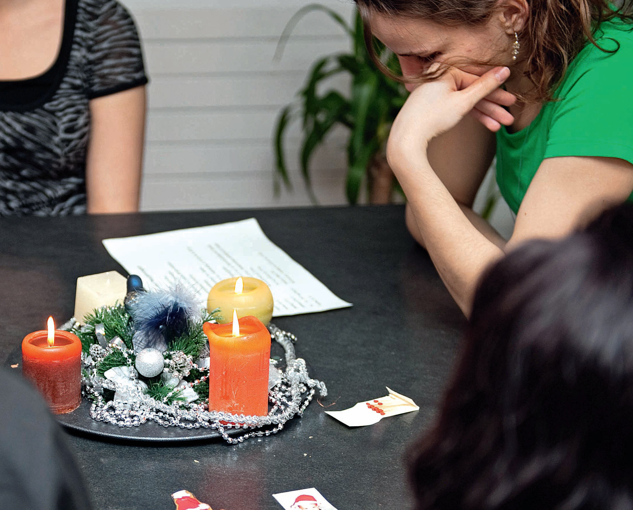 Ein Advenzkranz auf dem Tisch und mehrere Mädchen sitzen rundherum