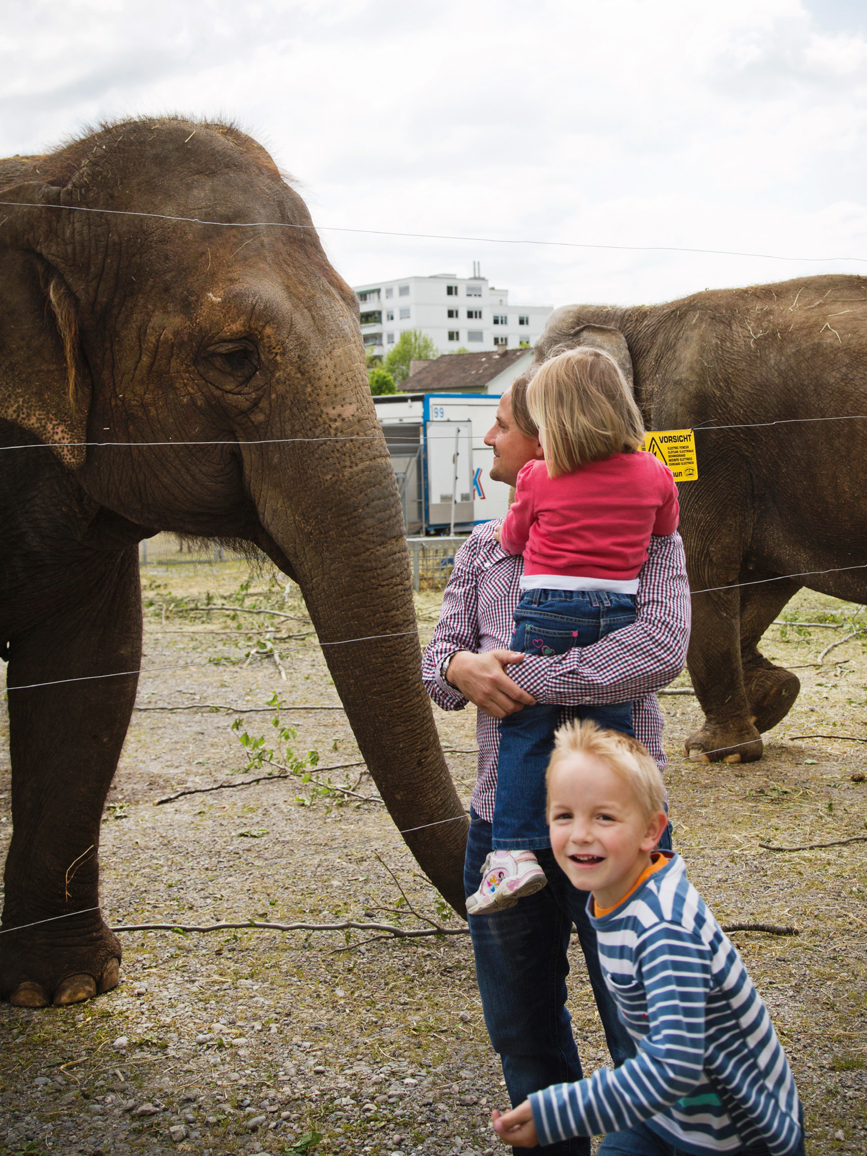 Mutter und zwei Kinder beobachten die Elefanten