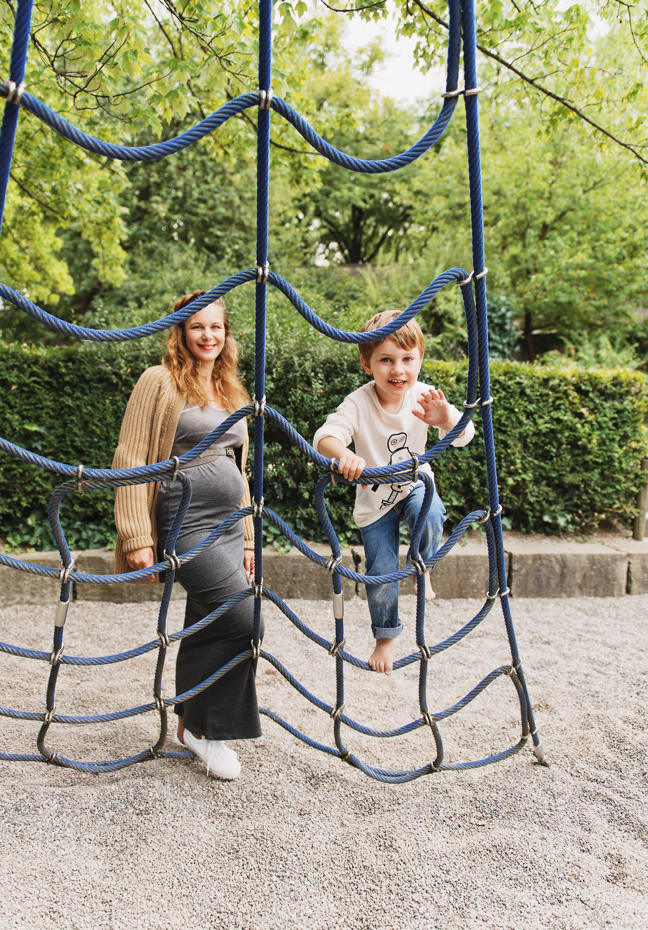 schwangere Frau mit Sohn auf dem Spielplatz