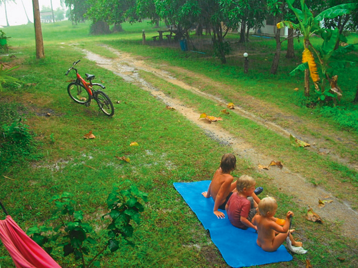 Kinder geniessen den warmen Regen in den Tropen