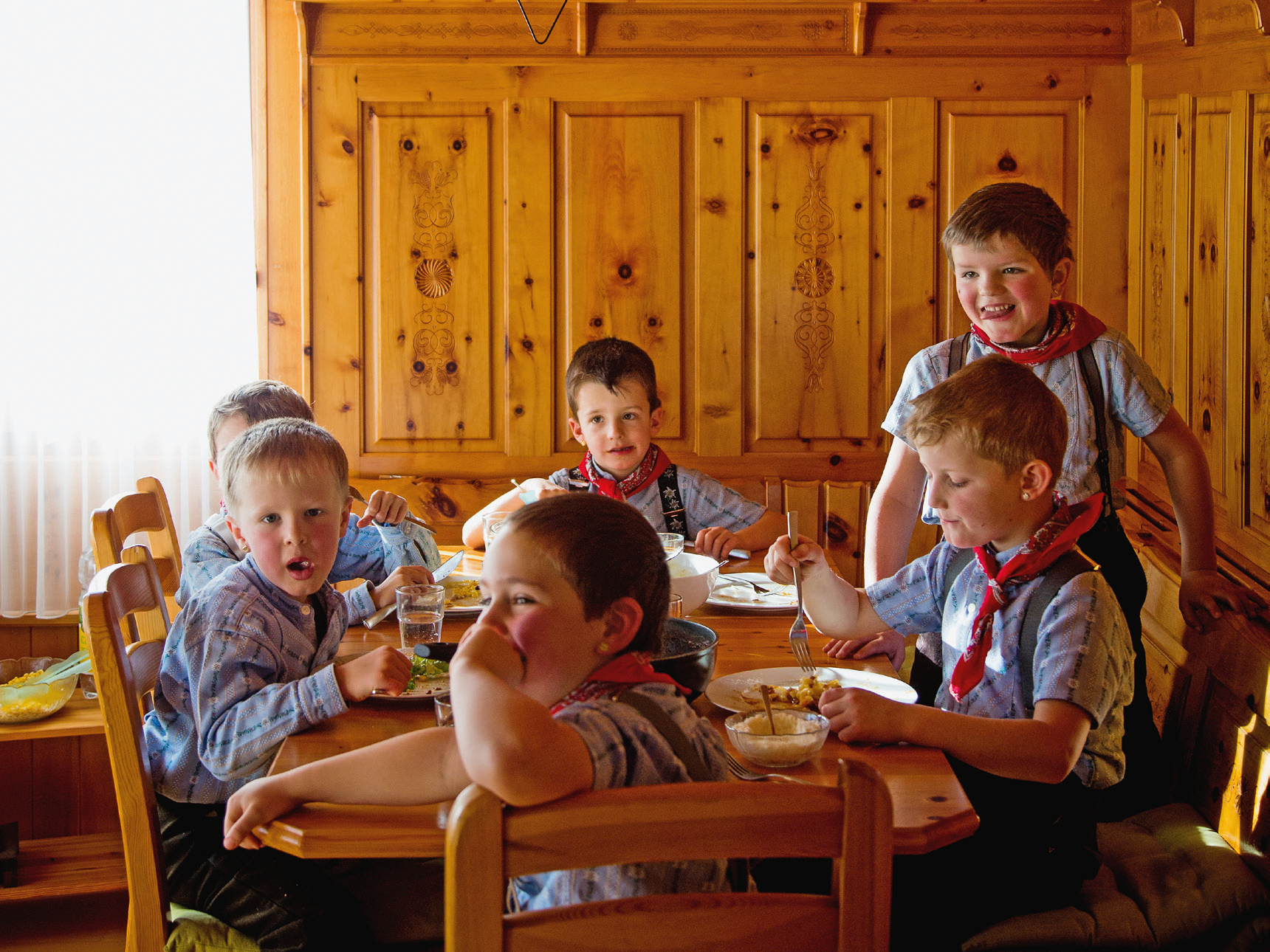 Kinder sitzen an einem Tisch und essen