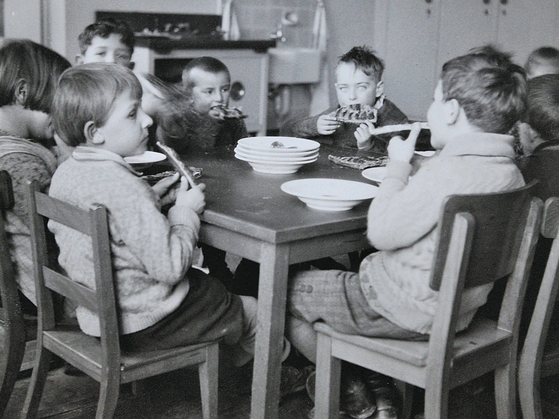 Kinder essen einen Kuchen am Tisch