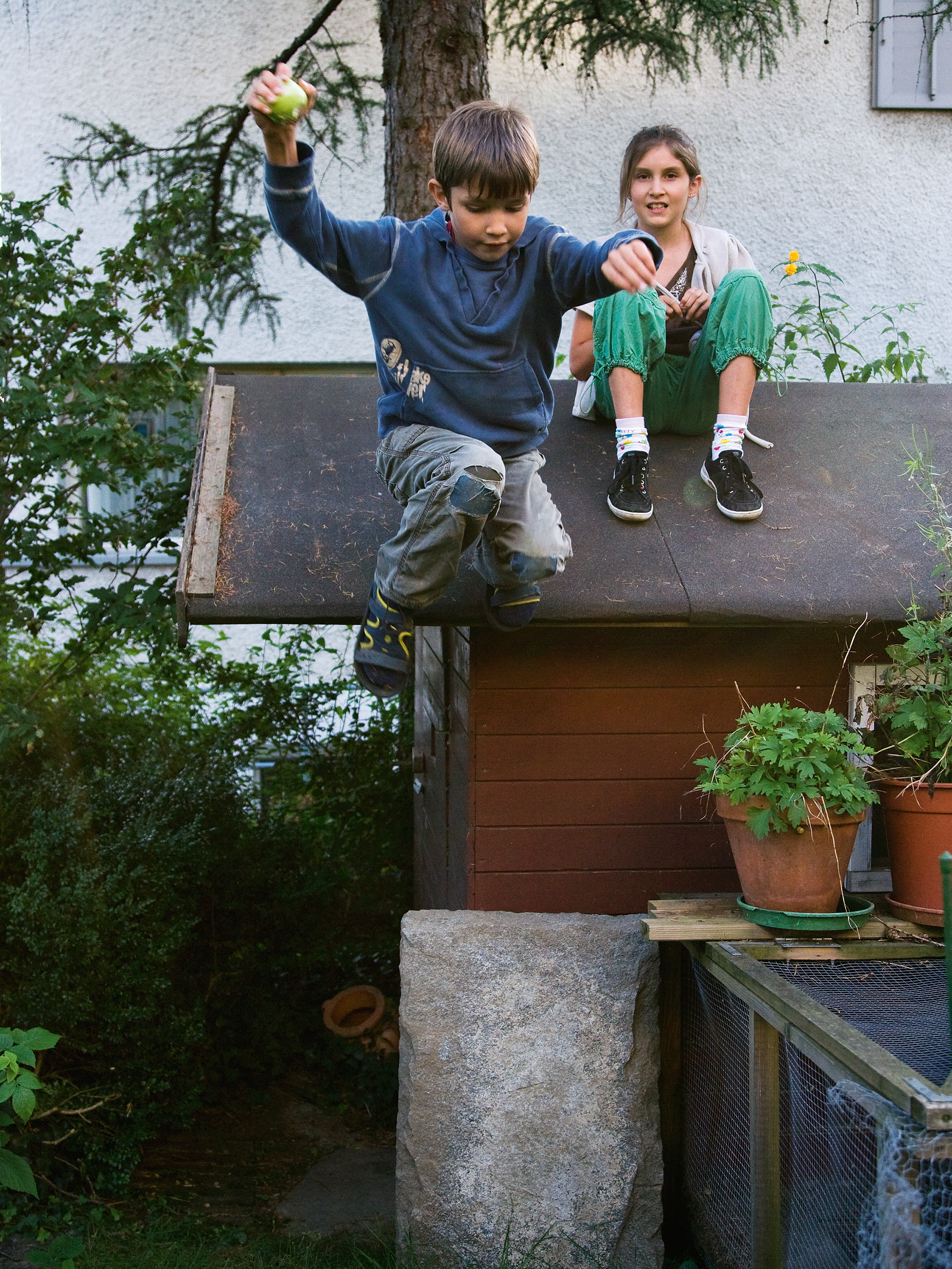 Junge springt vom Dach des Gartenhäschen