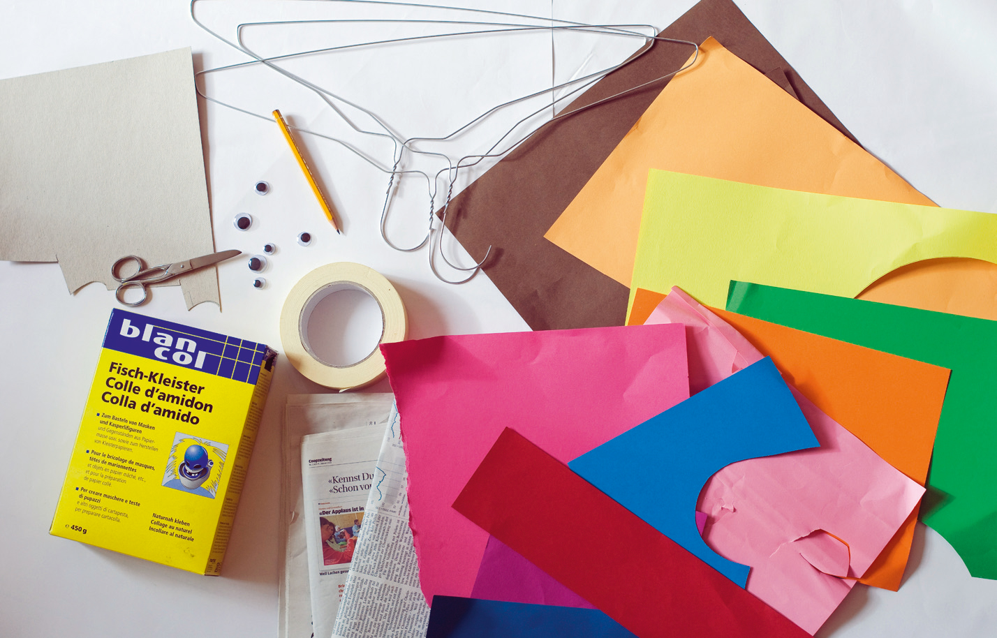 Drahtkleiderbügel, Zeitungen, Malerklebeband, farbiges Papier, Schere, Karton, Kleister, Wackelaugen zum Kleben, Leim.