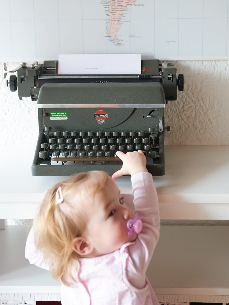 Kind spielt mit einer alten Schreibmaschine