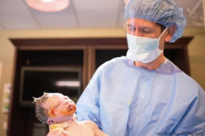 Arzt hält Neugeborenes