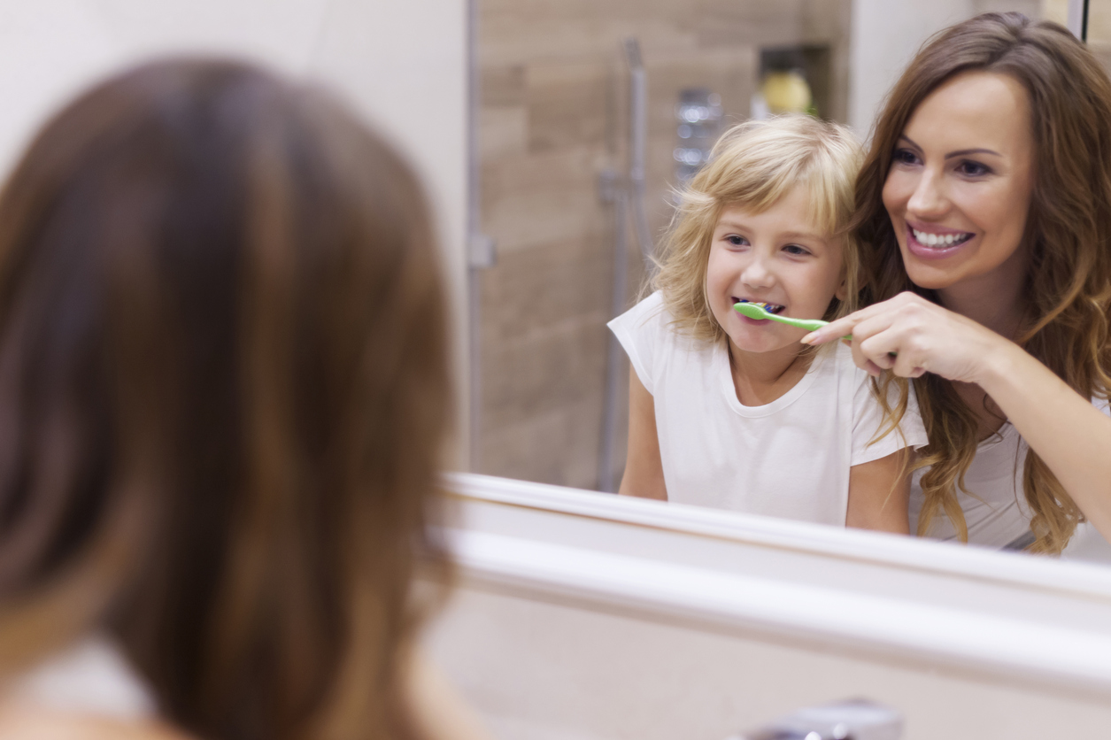 Mutter putzt Mädchen die Zähne