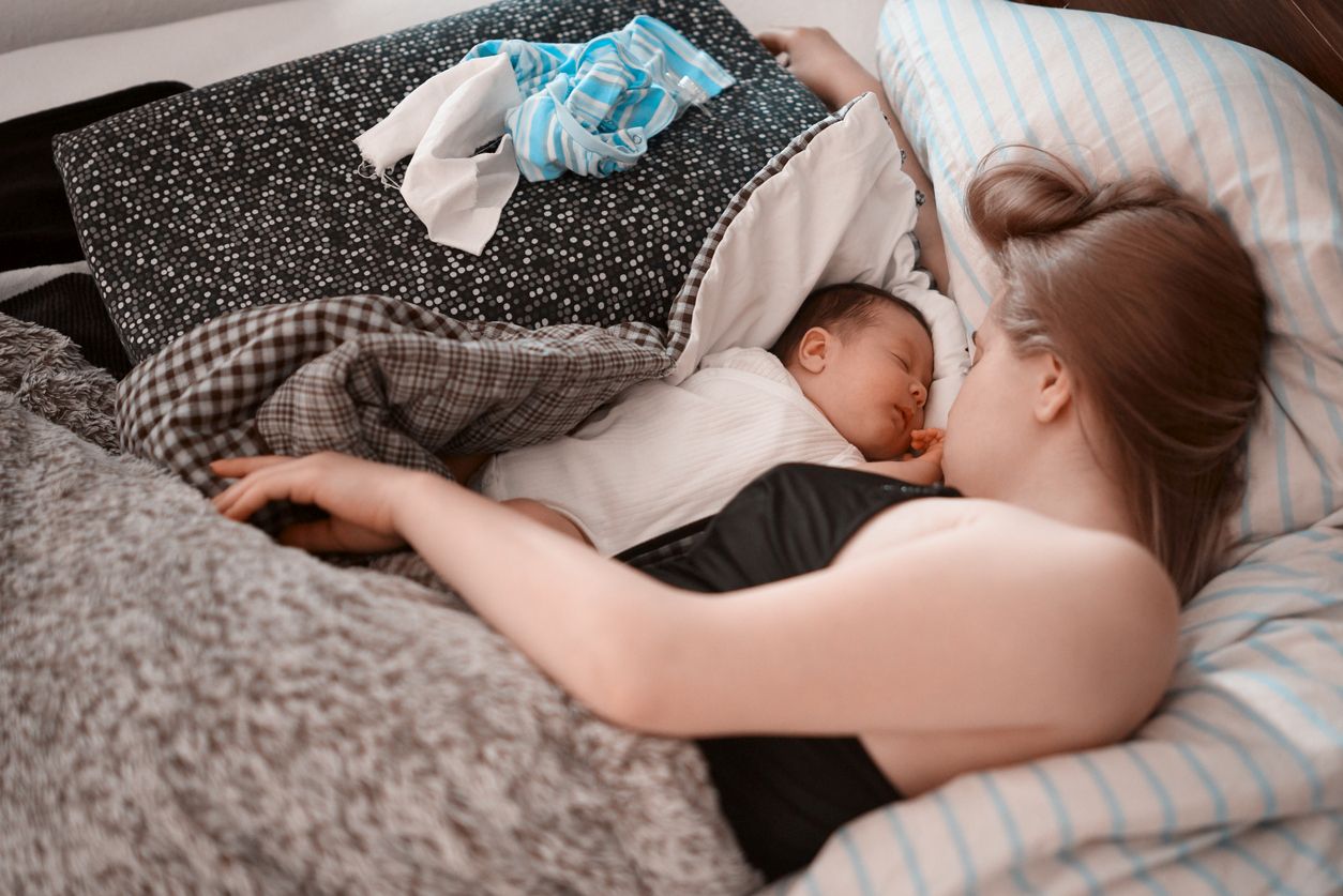 Baby mit Mama im Bett