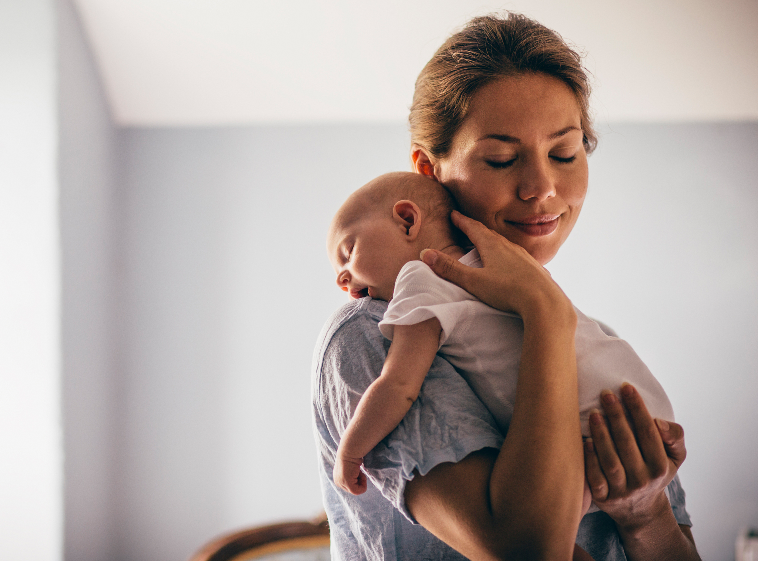 Mutter mit schlafendem Baby im Arm