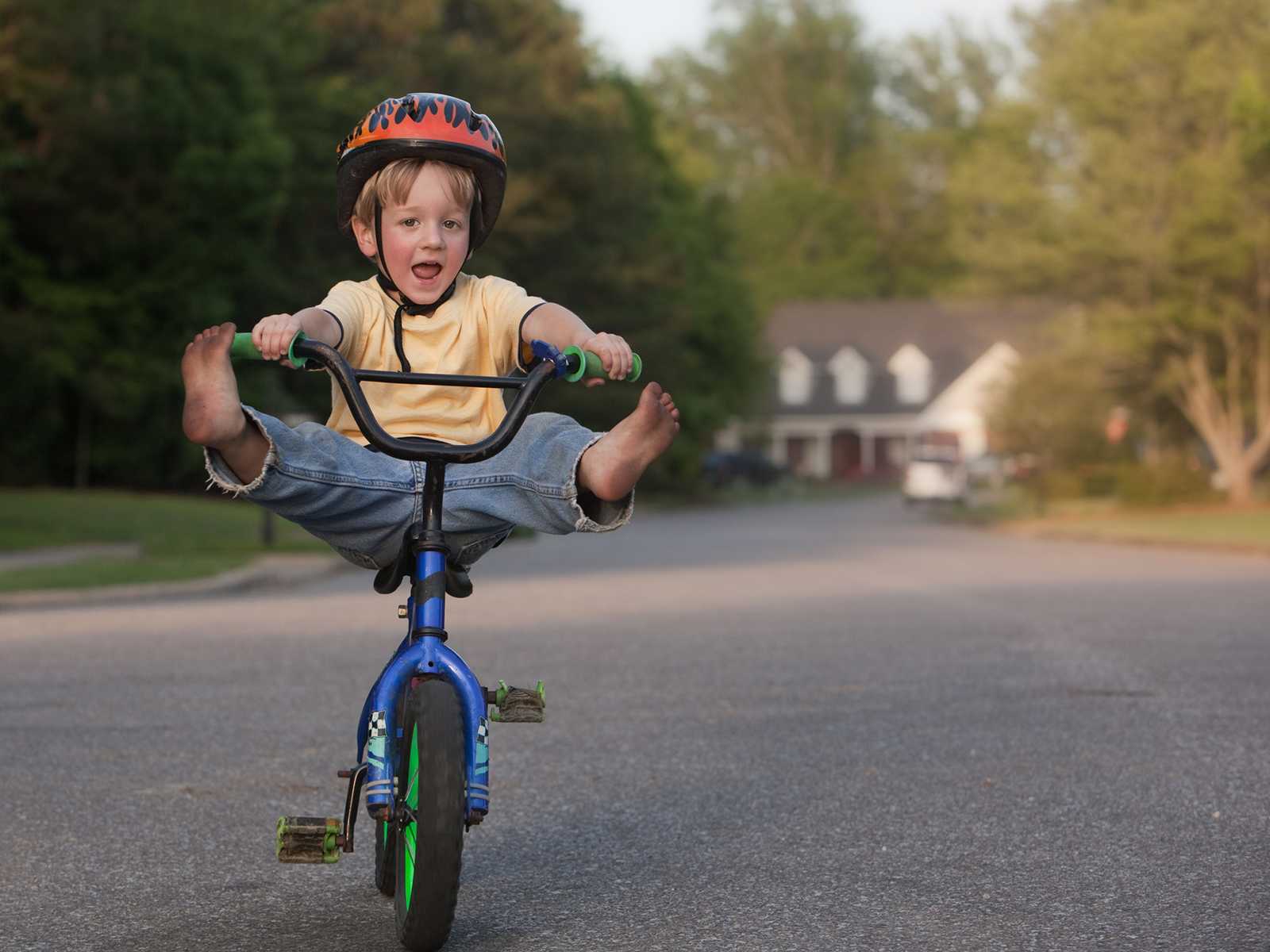 Junge auf Velo mit Beinen in der Luft