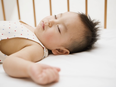 baby schlaeft im gitterbett