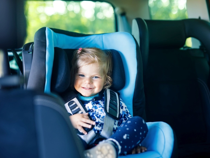 zufriedenes Kind in einem Autositz
