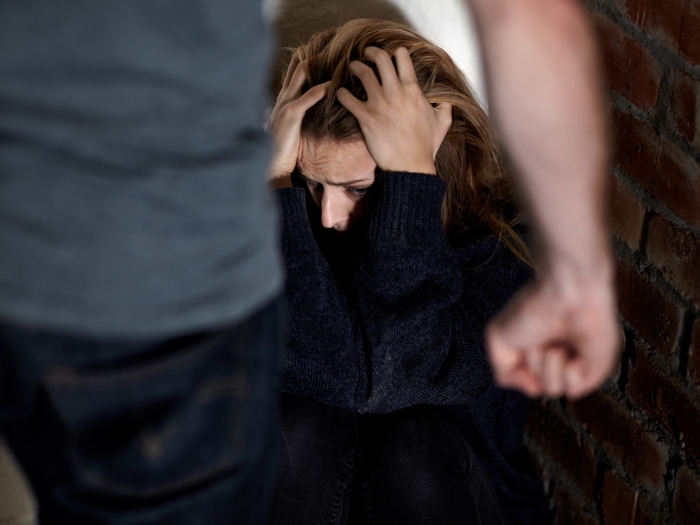 Mann mit Faust vor einer wehrlosen Frau