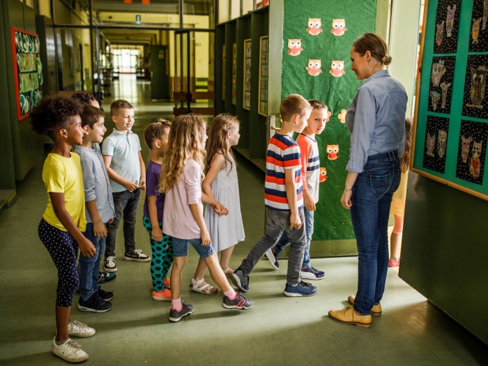 Lehrerin begrüsst Grundschüler zum Schuljahres-Start