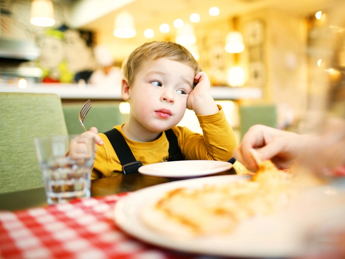 Ein Kind langweilt sich im Restaurant