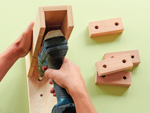 Damit die Löcher schön senkrecht gebohrt werden (8mm Holzbohrer), die Sägeführung als Bohrführung benutzen. Achtung, nicht durchbohren. Damit alle Löcher gleich tief werden, den Bohrer bei 1cm abkleben. Die Containerhölzer mit einem 10mm Holzbohrer ganz durchbohren.