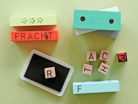 Die Seiten der Schiffscontainer mit Stempel beschriften und verzieren.