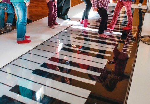 Kinderfüsse auf einem gezeichneten Klavier