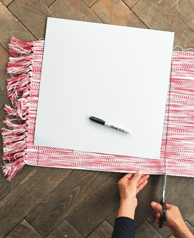 Kartonschablone erstellen – 40 auf 40 cm. Schablone mit wasserfestem Stift auf Teppich übertragen und mit Schere ausschneiden. Die Teppichstücke rund herum abzickzacken – am besten gleich zweimal – damit sie nicht ausfransen.