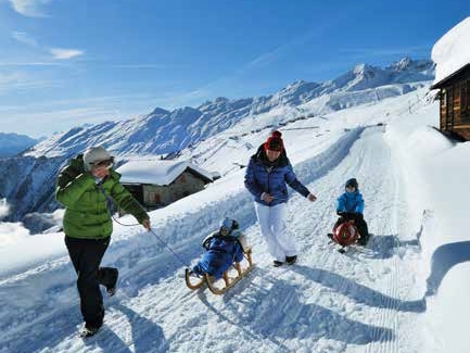 Eine Familie beim Schlitten fahren