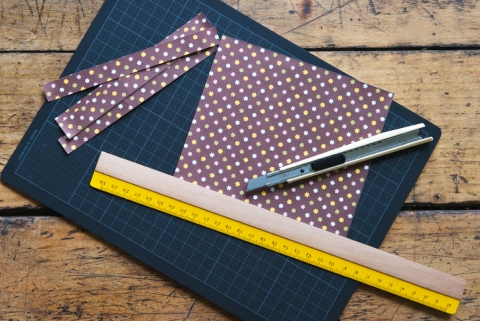 Einen 1,5 cm breiten Papierstreifen abmessen und aus Geschenkpapier zuschneiden.