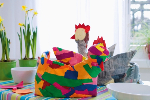 Vorgang mit farbigen «Papierfötzeli » wiederholen, dabei den Schnabel wie den Kamm mit roten Schnipseln überkleistern. Etwas Ostergras zum Auspolstern des Nests und ein schönes Plätzchen: Jetzt kann der Osterhase kommen!
