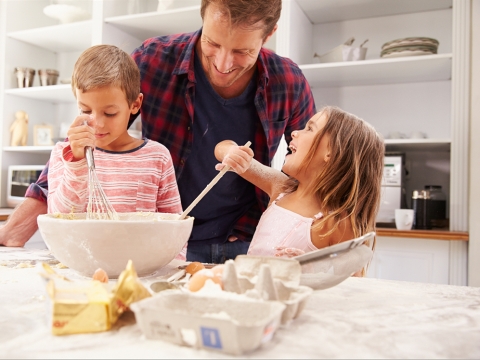 Mann und Kinder machen einen Kuchenteig