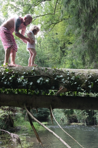 Aut einem Baumstamm balancieren Vater und Tochter