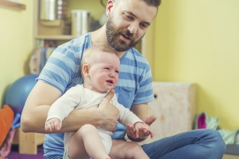 Vater mit Baby sitzend