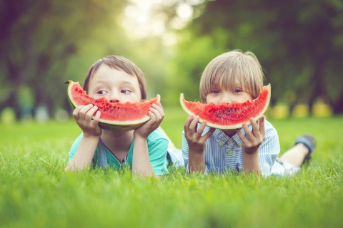 Kinder mit Melonenschnitzen