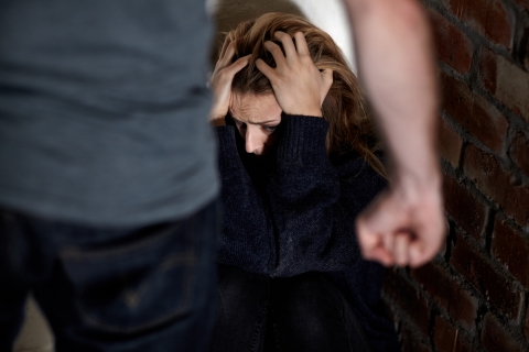 Mann mit Faust vor einer wehrlosen Frau
