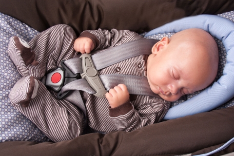 Ein Baby schläft in der Babyschale im Auto. 