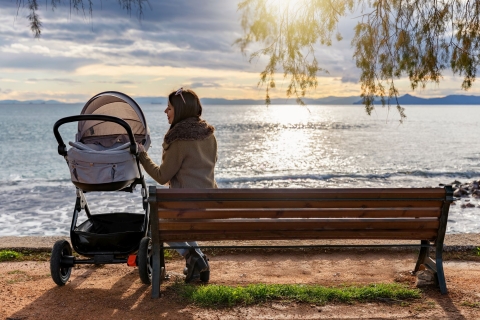 Im Kombikinderwagen schläft ein Baby am Meer. 