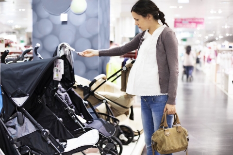 Schwangere Frau sucht Kinderwagen aus