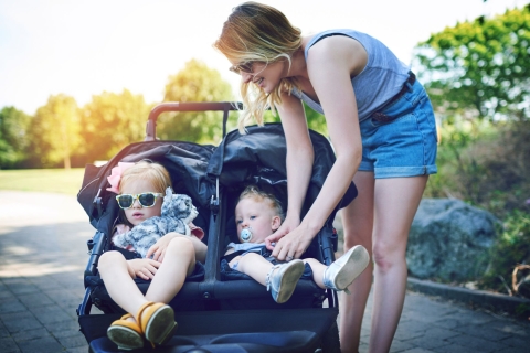 Zwei Geschwister im Tandemkinderwagen