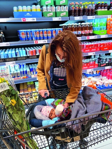 Die Autorin füttert das Roboterbaby vor dem Kühlregal.